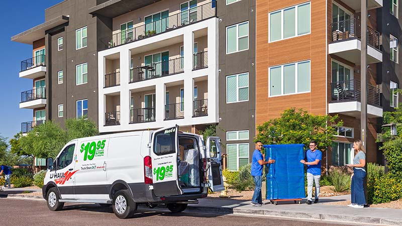 Two Service Providers help moving furniture for a customer from her apartment to her U-Haul rental cargo van.