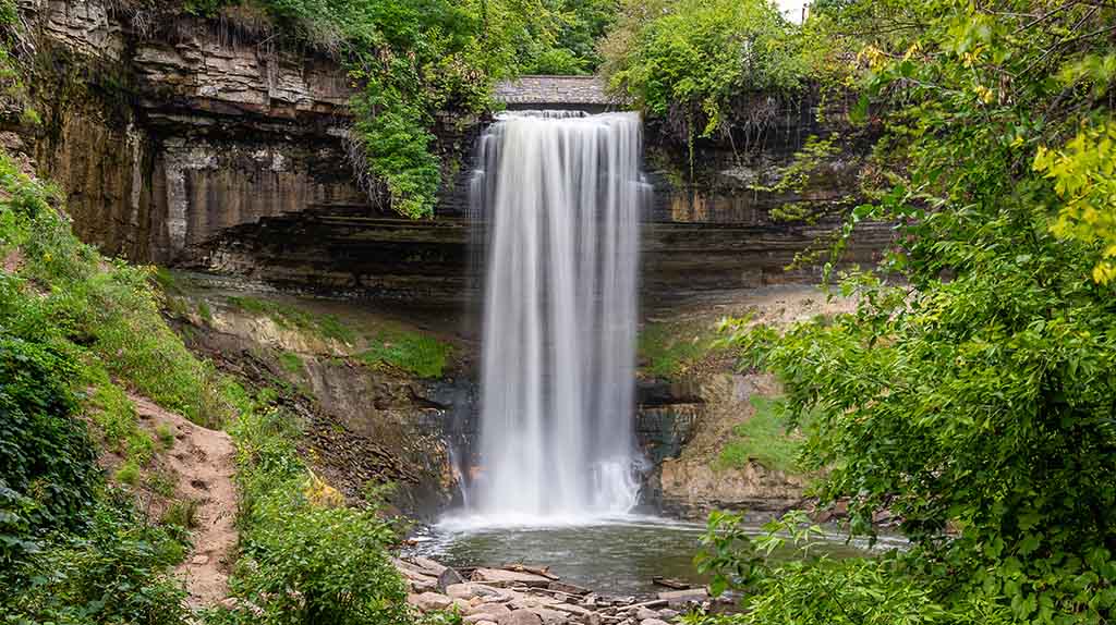 The 53-foot waterfall is seen pouring down water at Minnehaha Park. Minnehaha Park is one of the many places to explore when you move to Minneapolis.