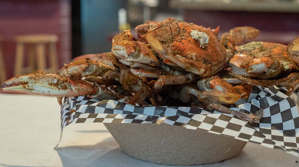 Steamed Chesapeake Bay blue crabs sit cooked with seasoning on a paper bowl. Baltimore is known for the city’s seafood scene.