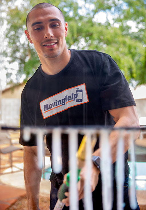 A Service Provider cleans the outdoor railing at a customer’s house on a sunny day.